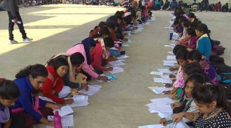 Students sit in the open for exams 