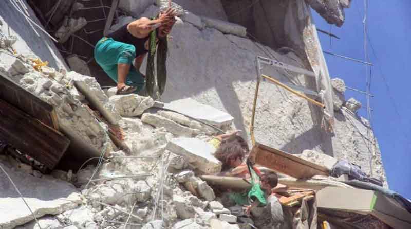 Sister grabbing baby dangling from bombed building in Syria