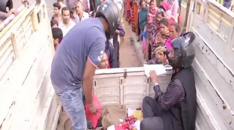 Cooperative employees sell onion wearing helmets fearing public outrage