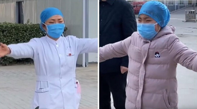 A nurse treating coronavirus patients, giving an air hug to her daughter