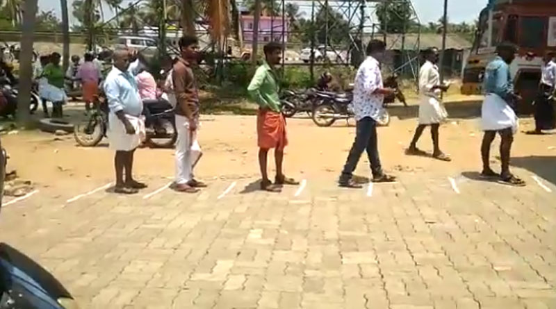 Coronavirus: People maintain distance while standing in queue to buy liquor