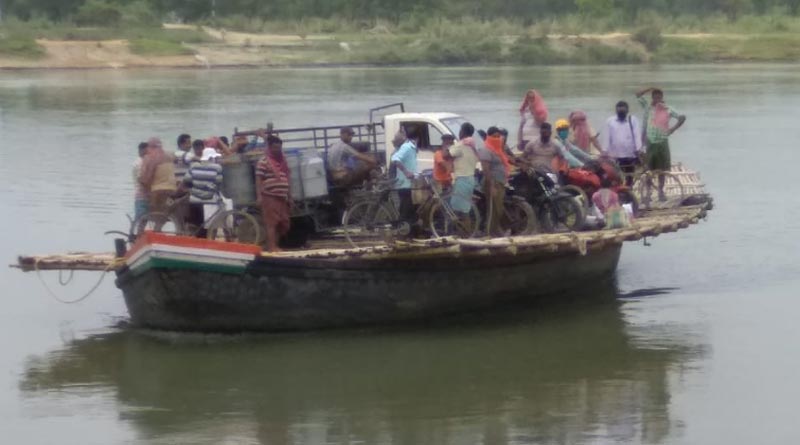 Gathering of people into a boat at Katwa ferry point, police makes them deborad