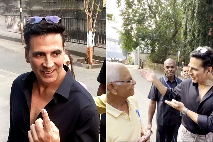 Akshay Kumar talks with a senior citizen after casting his vote