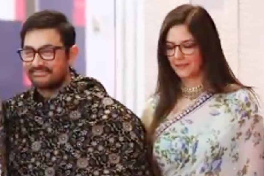 Aamir Khan and Gauri Spratt hold hands as they attend an event in China