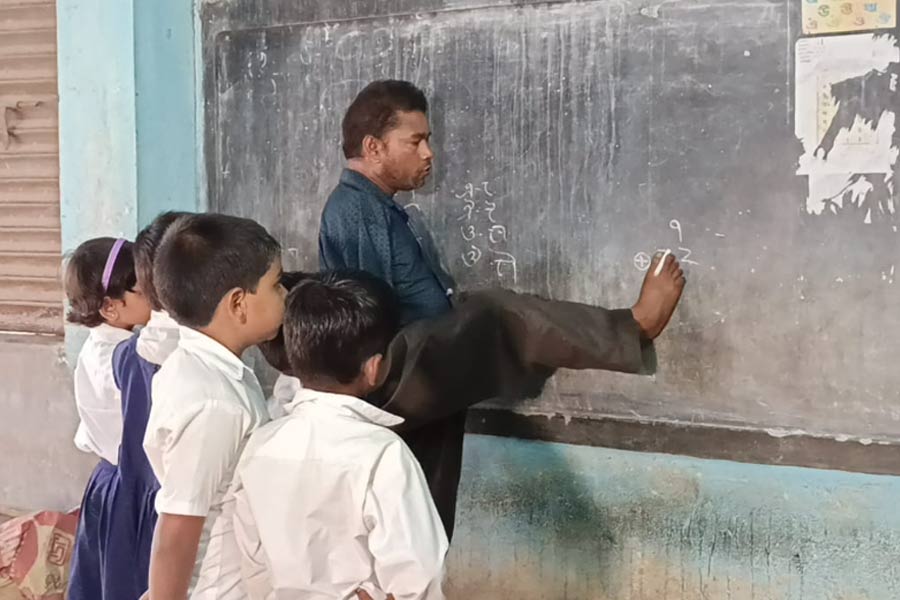 বাস্তবের জগন্নাথ! হাত নেই, পা দিয়েই ক্লাস করান আউশগ্রামের শিক্ষক